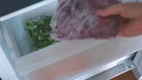 Hand pulling out bag of frozen beets from the freezer. Stock Footage 290479104