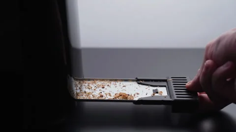 Hand pulling out the tray full of crumbs from a toaster Stock Footage 260238726