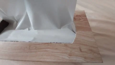 Hand pulling out white paper tissue from wooden box dispenser Stock Footage 333642073