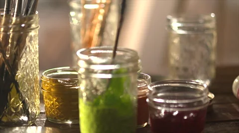 Hand pulling paint brush out of a jar Stock Footage 56238522