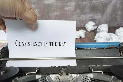 Hand pulling a piece of white paper with quote from an old classic typewriter Stock Photos