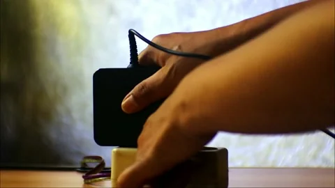 Hand pulling plug of electrical appliances connected notebook. Get out of Stock Footage 181099907