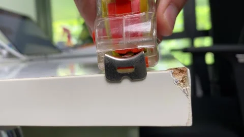 Hand pulling roll of measuring tape white table in office room, sunny outside Stock Footage 249375467