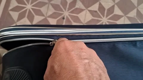 Hand pulling silver zipper on blue travel suitcase video footage Stock Footage 339248220