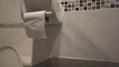 Hand pulling tissue paper in toilet, close up shot in bathroom, tissue paper Stock Footage 122883543