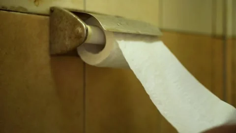 Hand pulling toilet paper from a roll Stock Footage 322205704
