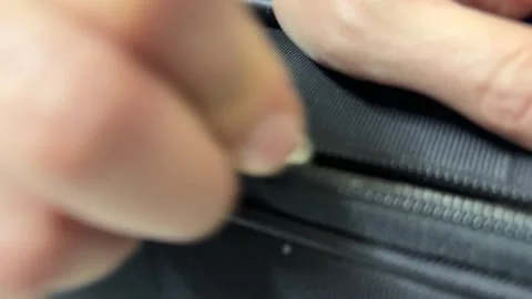 Hand pulling zipper on black suitcase, closing luggage for travel 스톡 동영상 336977280