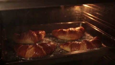 Hand pulls croissants out of the oven Stock Footage 72228489