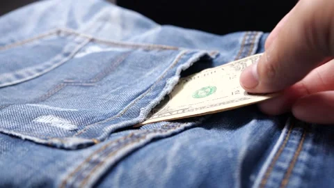 Hand pulls a dollar bank out of the pocket of a blue denim jacket Stock Footage 144514904