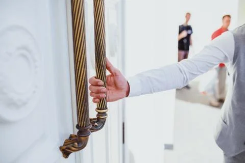 Hand pulls doorknob	 Stock Photos