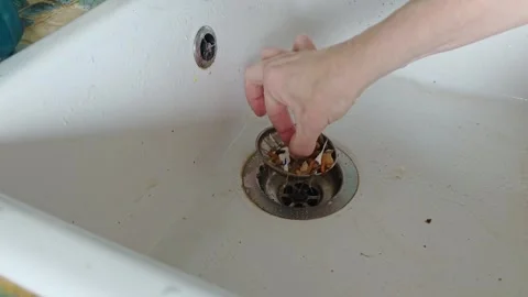 Hand pulls out a clogged drain grate filled with debris from the sink, kitc.. Video stock 344768063