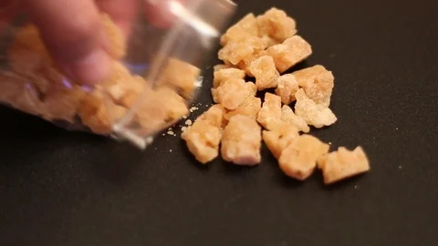 Hand pulls out crystalline substances from a plastic bag Vidéo 107938424
