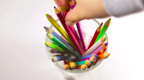 Hand pulls out a pencil from the glass with colored pencils Stockbeeldmateriaal 65384628