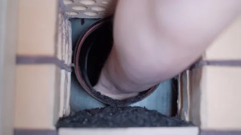 A hand pulls out soot from a chimney. Cleaning soot from the bottom of the Stock Footage 305553525