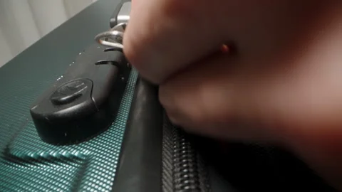 A Hand pulls the zipper closed on the suitcase, securing the contents before Stock Footage 282294361
