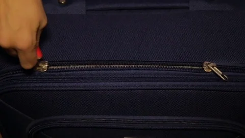 The hand pulls the zipper on the luggage Stock Footage 80980773
