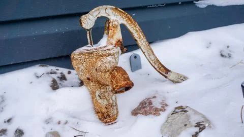 Hand pump outside in the winter Stock Photos