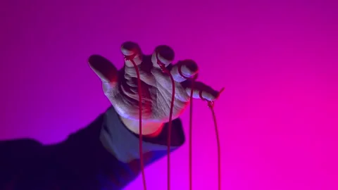 Hand with Puppet Strings in Neon Pink Light Control and Manipulation Concept Stock Footage 345096026