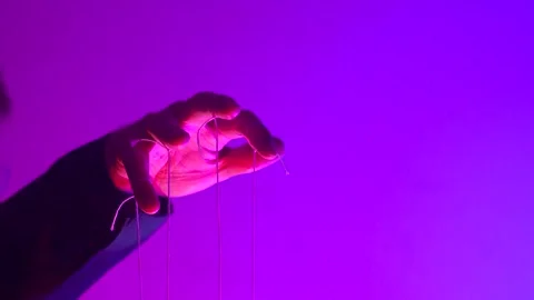 Hand with Puppet Strings in Neon Pink Light Control and Manipulation Concept Stock Footage 345096033