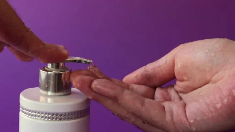 Hand push dispenser and liquid soap squeezed out to fingers, closeup shot Stock Footage 138124907