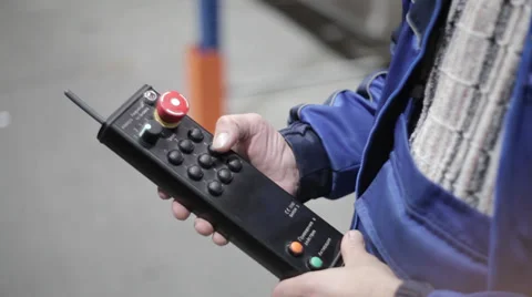 Hand pushes a button on an industrial remote control in a logistics warehouse wi Stock Footage 36840784