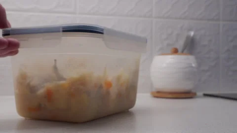Hand Pushes Container of Warm Stew Across Counter for Dinner, Soft Scrape Video stock 321347162
