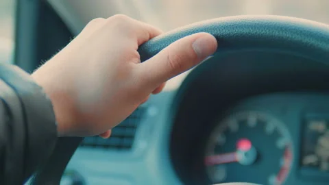 A hand pushes the cruise control button on a steering wheel. Stock-Footage 89542790