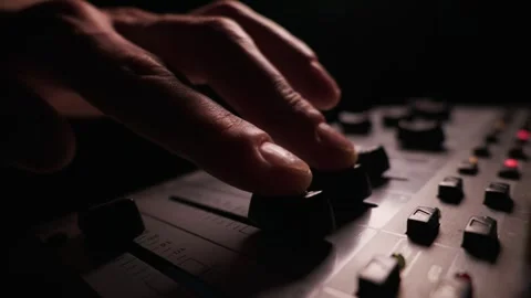 Hand Pushes Up a Fader on a Professional Audio Mixing Console in a Studio Stock Footage 334736795