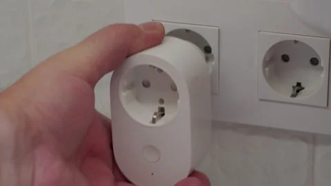 Hand Pushes Smart Plug into Wall Socket, Connecting to Electricity with Click. Stock Footage 321526446