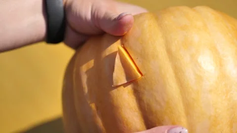A hand pushes a triangular eye out of a pumpkin. preparation for Halloween... Stock Footage 253217704
