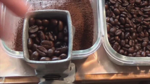 The hand is pushing aromatic and freshly roasted coffee beans ground in an old Video stock 144094780