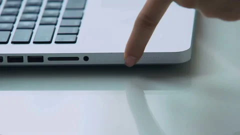 Hand pushing battery capacity indicator button laptop modern computer technology Stock Footage 98819377