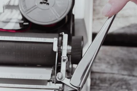 Hand pushing carriage return lever on vintage typewriter macro close up Stock Photos
