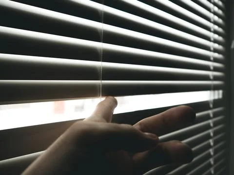 Hand is pushing closed blinds Foto stock