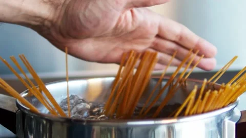 Hand pushing down spaghetti in the boiling water. Stock Footage 150184872