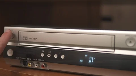 Hand pushing the eject button and taking a tape from silver videorecorder Stock Footage 111260982