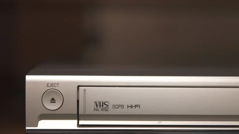 Hand pushing the eject button and taking a tape from silver videorecorder Stock Footage 111261290