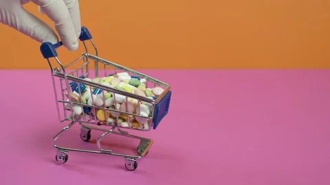 Hand pushing a mini trolley with pills. Stockbeeldmateriaal 126556150