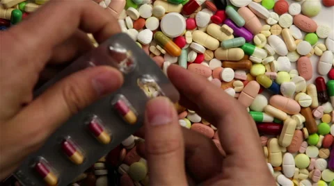 Hand pushing pills out of package Stock Footage 6767865