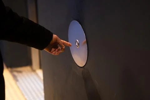 Hand pushing round metal elevator button choosing floor Fotos de archivo
