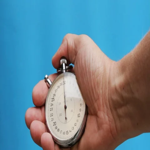 Hand pushing a stopwatch button to stop it against a removable Stock Footage 69727471