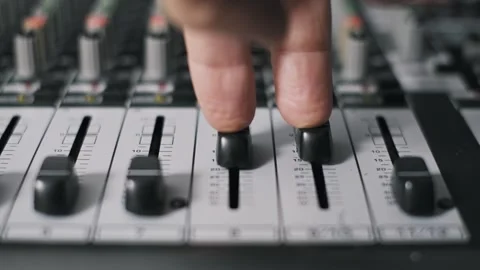 Hand Pushing Up Two Faders on Audio Console Video stock 318481586