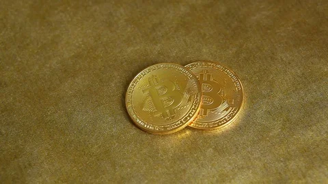 Hand put Bitcoin or cryptocurrency on golden table and take one back in the end Stock Footage 84942746