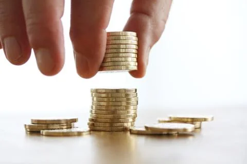 Hand put coin to money stack on white background. Close-up of hand Stock Photos