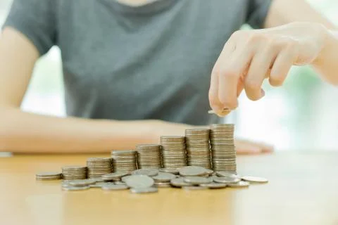 Hand put coins to stack of coins Stock Photos