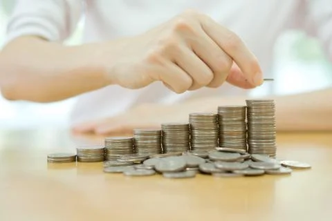 Hand put coins to stack of coins Stock Photos