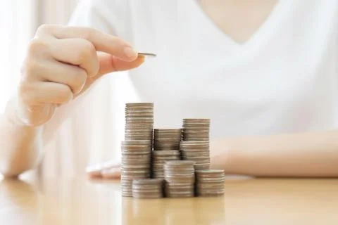 Hand put coins to stack of coins on white background Stock Photos