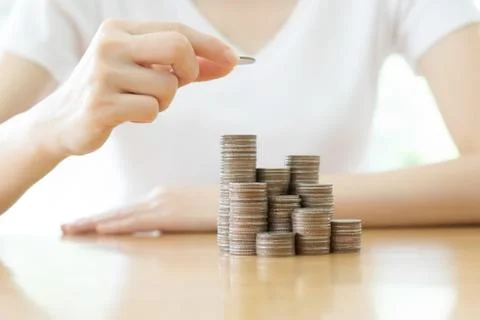 Hand put coins to stack of coins on white background Stock Photos