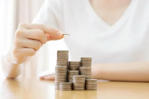 Hand put coins to stack of coins on white background Stock Photos