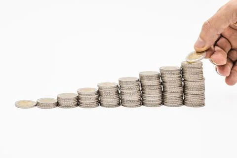 Hand put coins into the stack of coins. Business and financial growth and Stock Photos
